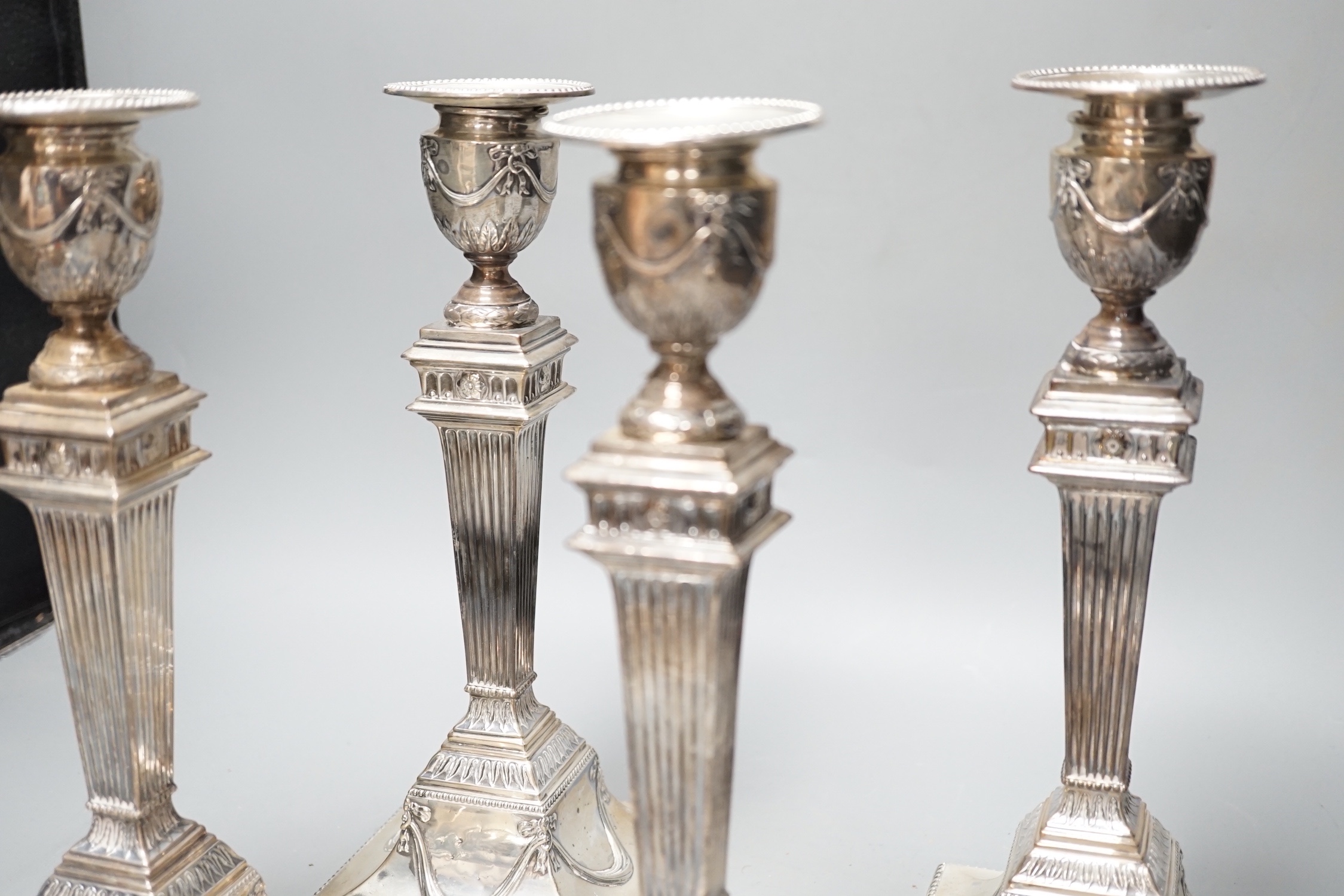 A set of four late Victorian silver candlesticks, with fluted, tapered stems, Hawksworth, Eyre & Co, Sheffield, 1890, 27.5cm, weighted (a.f.).